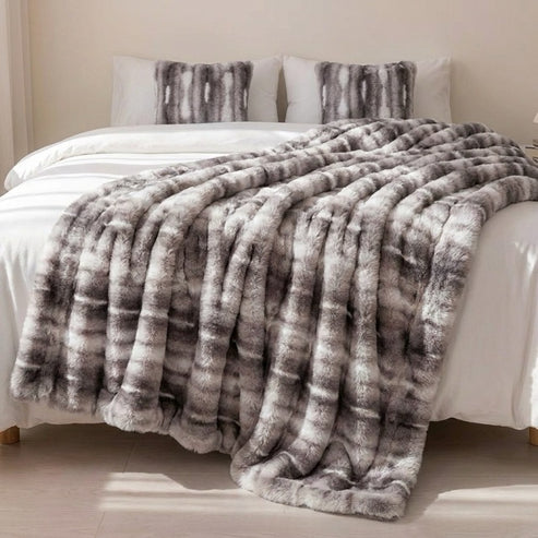 Grijze Cloud-plaid over een tweepersoonsbed met wit beddengoed