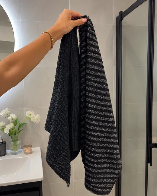 Twee Wove-handdoeken hangen aan de douchewand