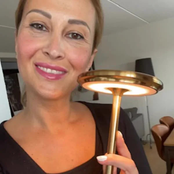 Klant houdt de gouden Copenhagen lamp voor zich